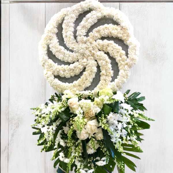 White floral funeral wreath with a cascading bouquet of roses and orchids