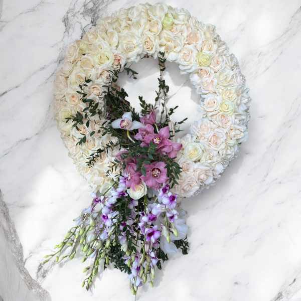 Heart-shaped floral wreath with cream roses and pink orchids