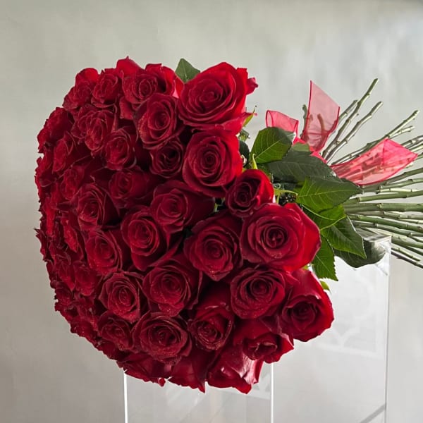 Large bouquet of red roses with pink ribbon accents