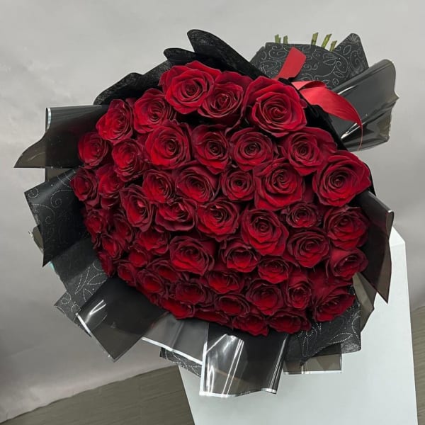 Large bouquet of red roses wrapped in black paper