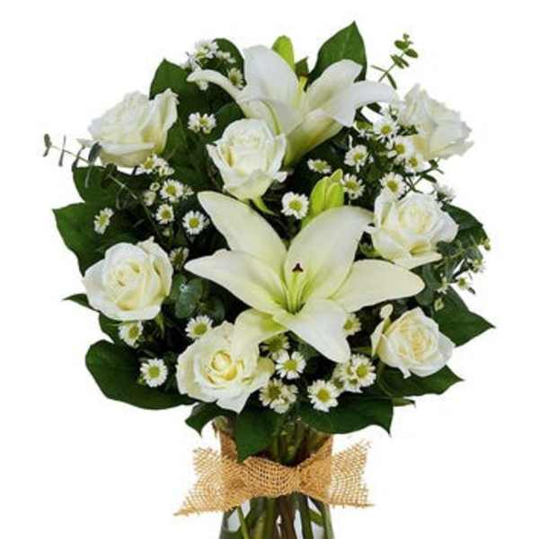 White lilies and roses in a glass vase with burlap ribbon