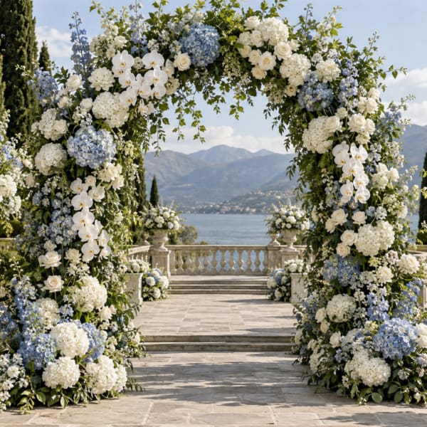 Large floral arch with white and blue flowers overlooking a lake