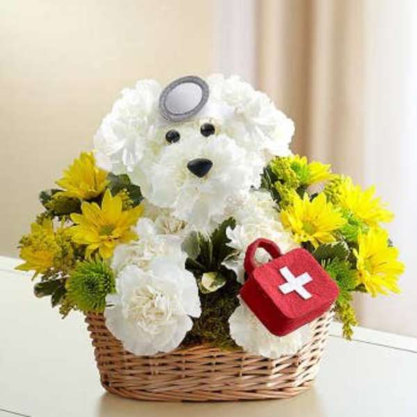 White teddy bear floral arrangement in a wicker basket with yellow flowers
