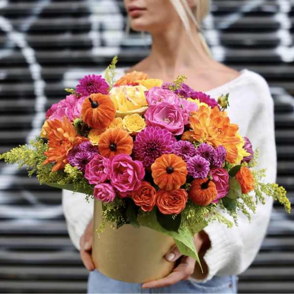Bright mixed bouquet in a round box with pink, orange, and yellow flowers
