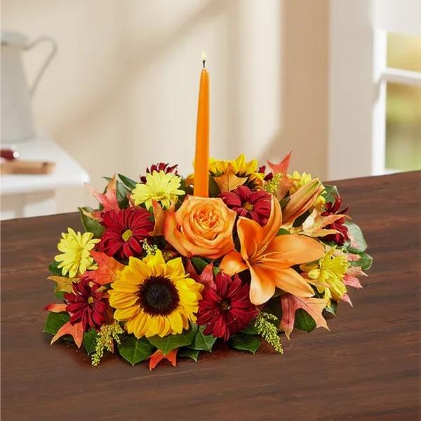 Autumn floral centerpiece with a tall orange candle