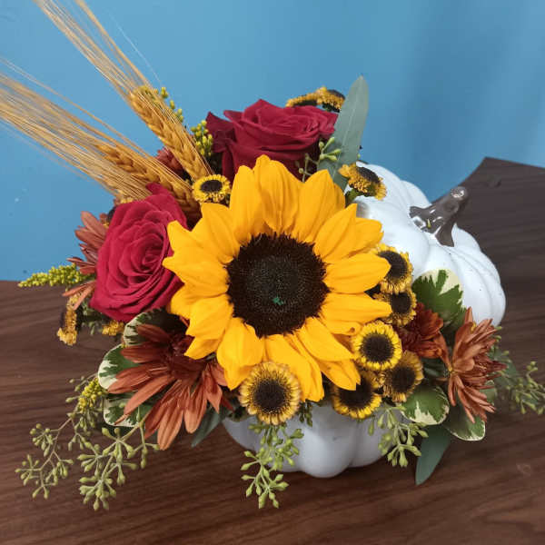 Sunflower and rose arrangement in a white pumpkin container