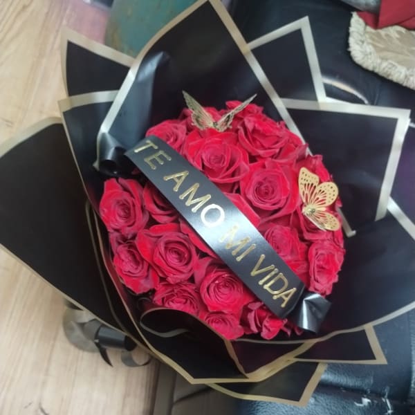 Bouquet of red roses wrapped in black paper with a ribbon