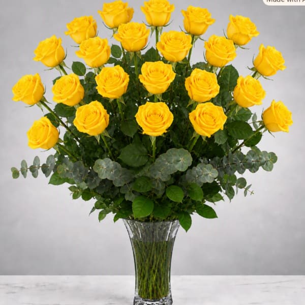 Yellow roses arranged in a clear glass vase with greenery