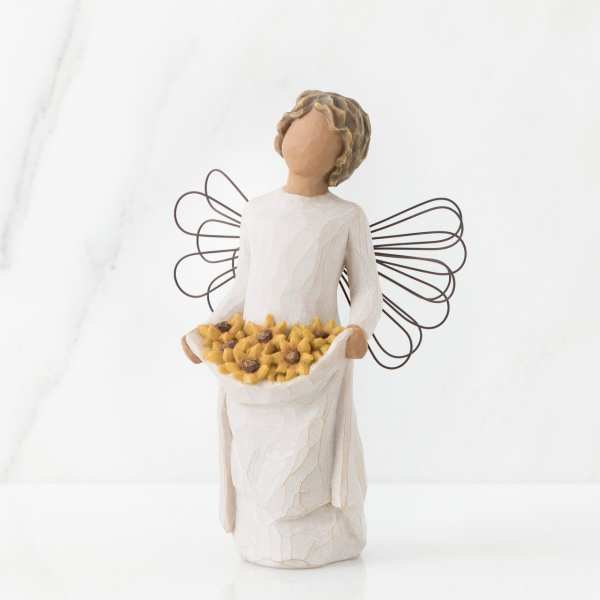 Carved angel figurine with wire wings holding a skirtful of small yellow flowers