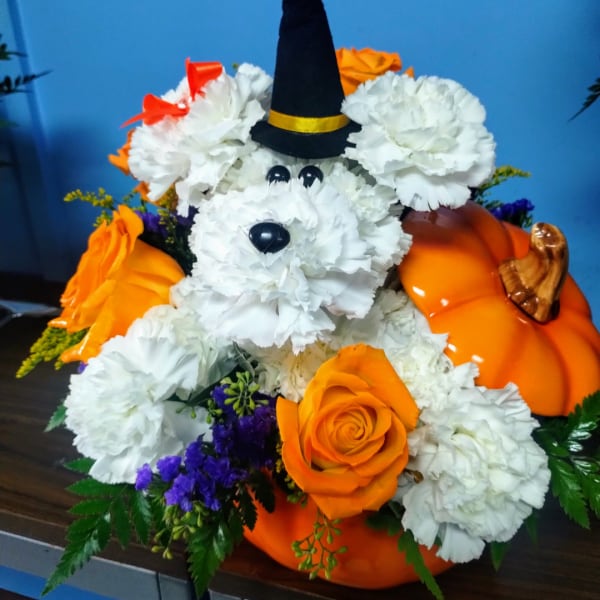 Halloween floral arrangement shaped like a dog with a witch hat and pumpkins