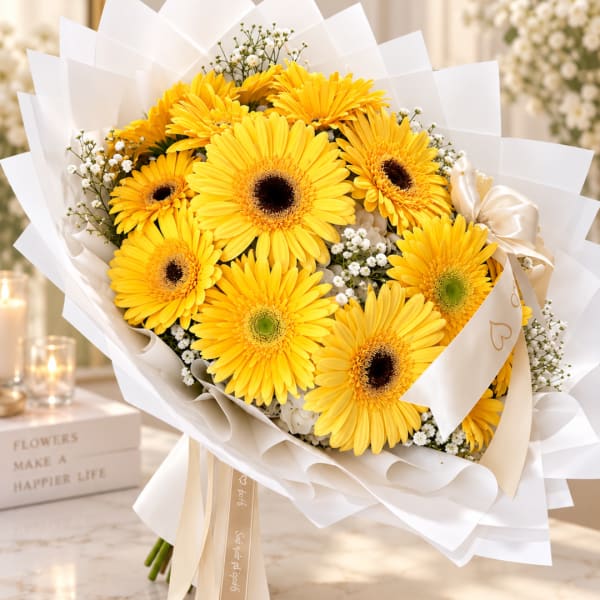 Bouquet of yellow gerbera daisies wrapped in white paper with a satin ribbon