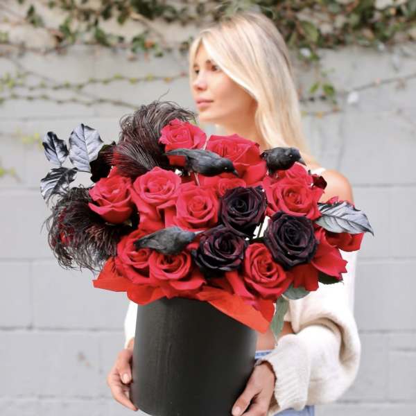Woman holding a black box of red and black roses