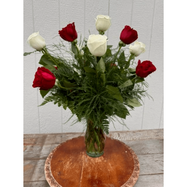 Red and white roses in a clear glass vase