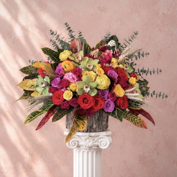 Colorful bouquet of roses and orchids in a rustic container