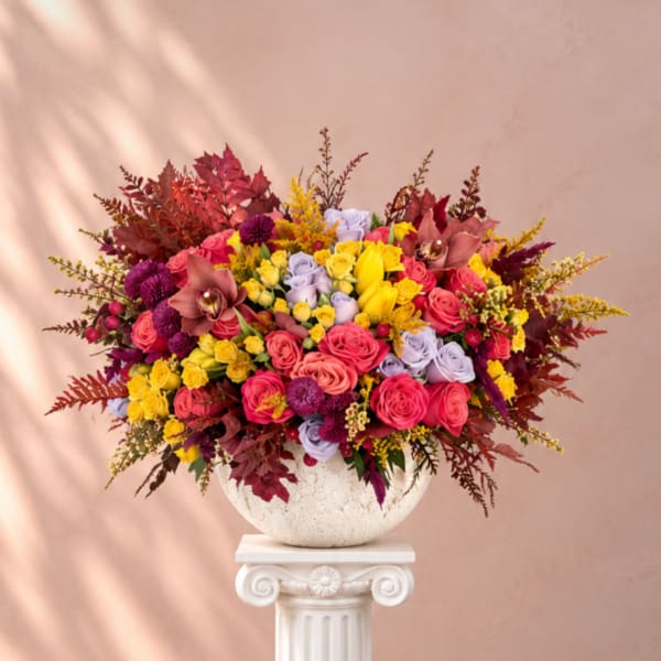 Colorful bouquet of roses and orchids in a white vase