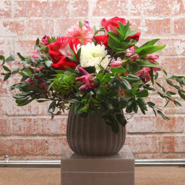 Red and pink mixed bouquet in a ribbed vase