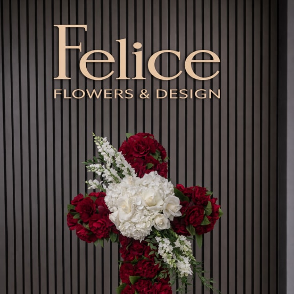 Red and white floral cross on a wooden stand