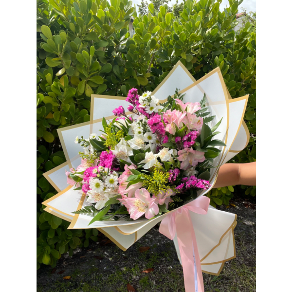 Pink and white mixed bouquet wrapped in white paper with a pink ribbon