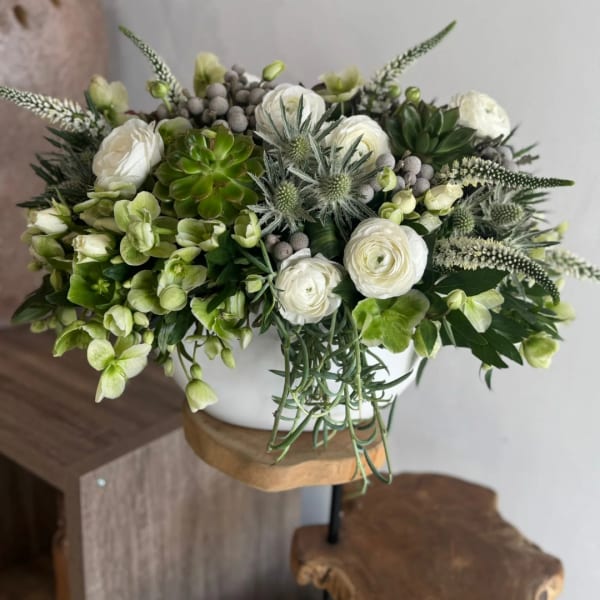 White and green floral arrangement in a white vase