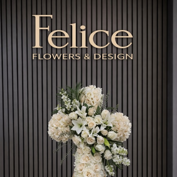 White floral standing cross on an easel