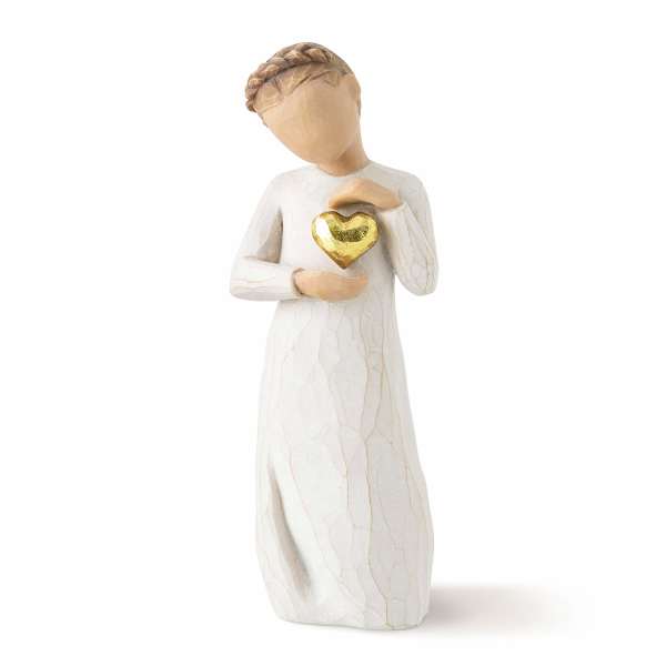 White figurine of a person holding a gold heart