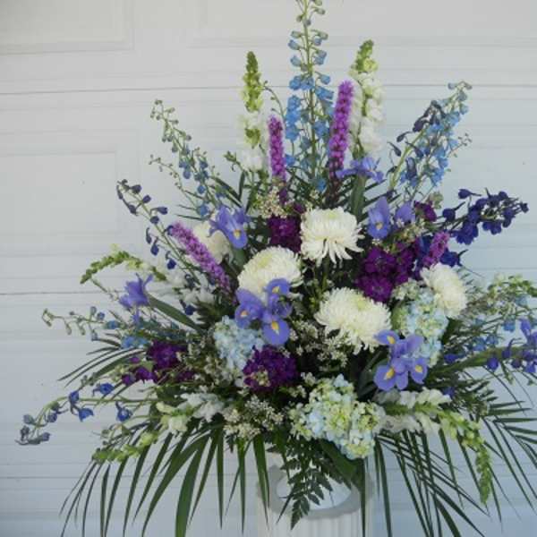 Large blue, purple, and white floral arrangement in a vase