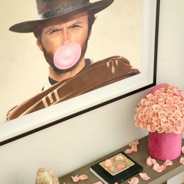 Pink rose arrangement in a cylindrical box on a shelf