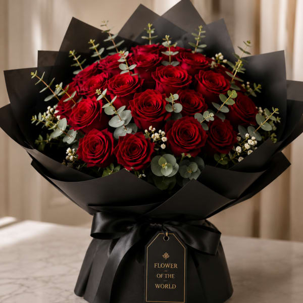 Bouquet of red roses wrapped in black paper with a ribbon and tag