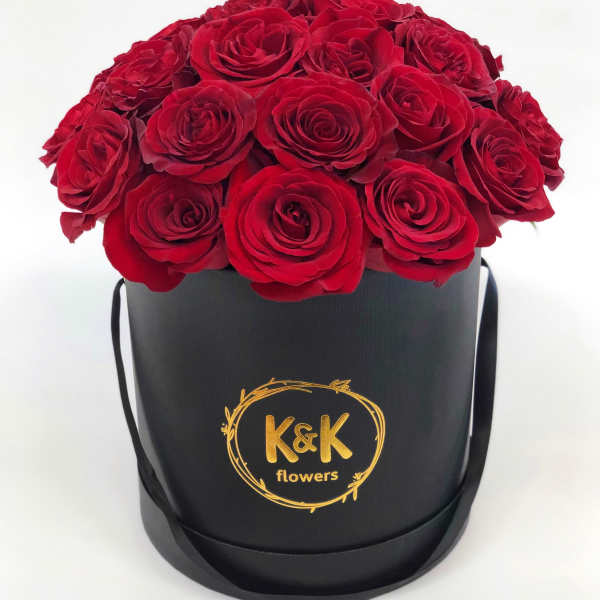 Red roses arranged in a black round hat box
