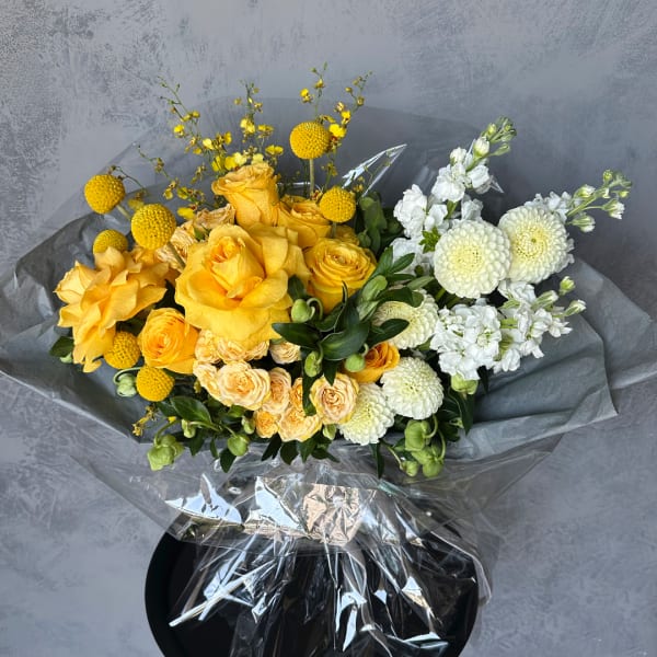 Yellow and white mixed bouquet wrapped in clear plastic