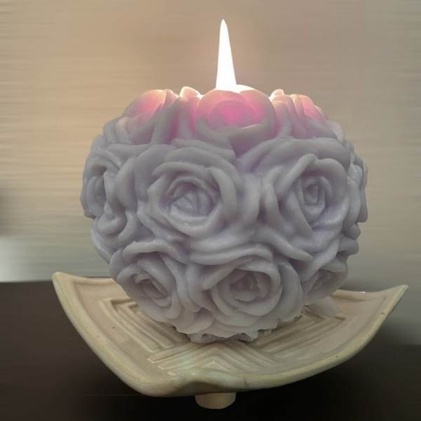Rose-shaped candle in a shallow ceramic dish