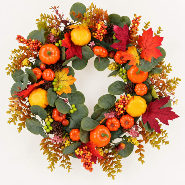 Autumn wreath with pumpkins, berries, and colorful leaves