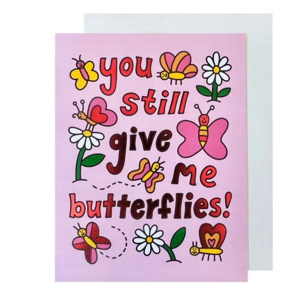 Pink greeting card with butterflies and daisies reading "you still give me butterflies!"