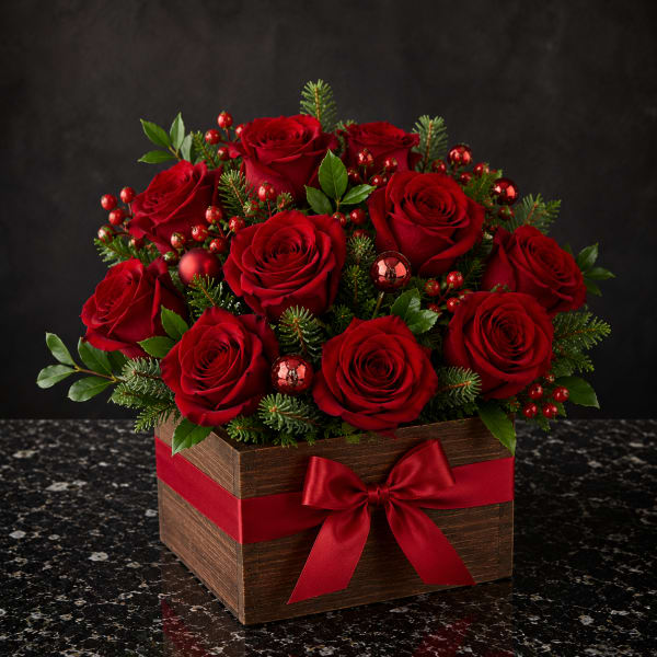 Red roses arranged in a wooden box with a red ribbon bow