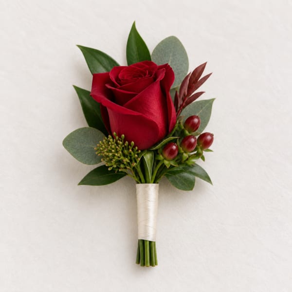 Single red rose boutonniere with greenery and berries