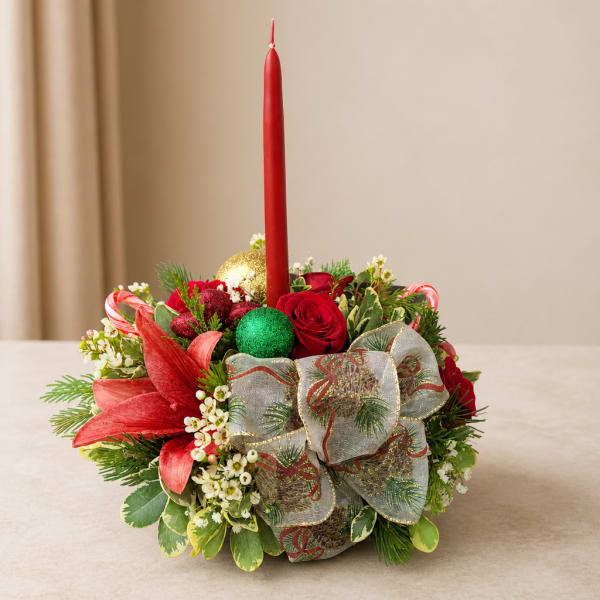 Holiday floral centerpiece with a red candle and ribbon