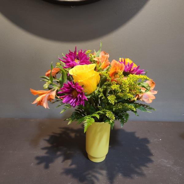 Yellow rose bouquet with purple daisies and orange alstroemeria in a yellow vase