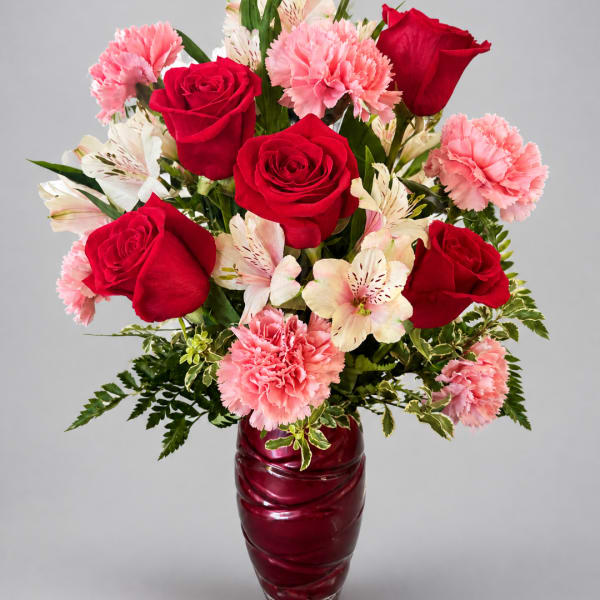 Red roses and pink carnations in a burgundy vase