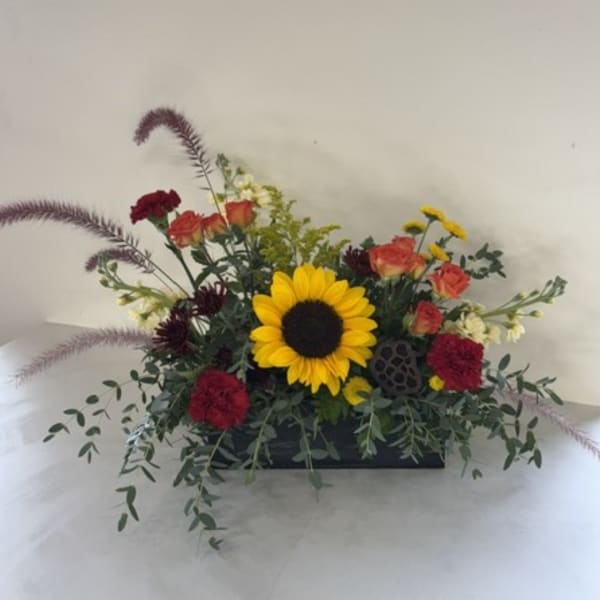Sunflower and mixed flower arrangement in a low black container