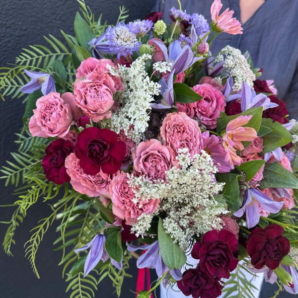 Bouquet of pink and burgundy roses with purple flowers and white filler