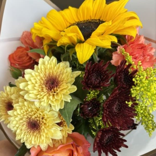 Bouquet with a sunflower, yellow daisies, and orange roses