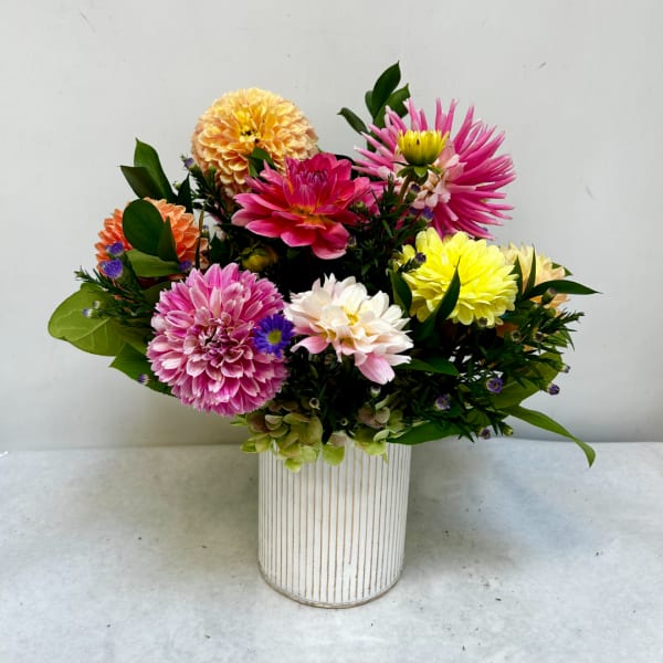 Colorful mixed chrysanthemum bouquet in a striped white vase