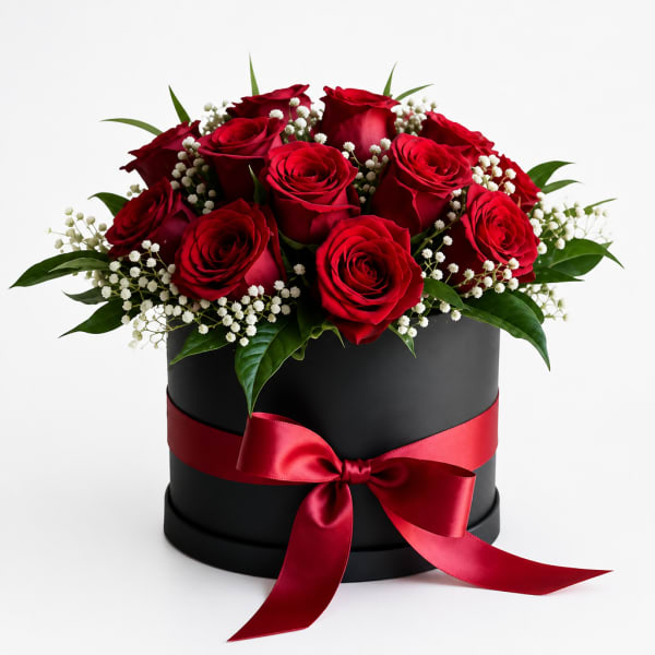 Red roses arranged in a black round box with a red ribbon