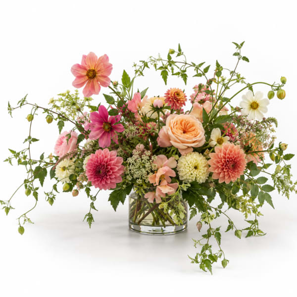 Mixed pink and peach flowers in a clear glass vase
