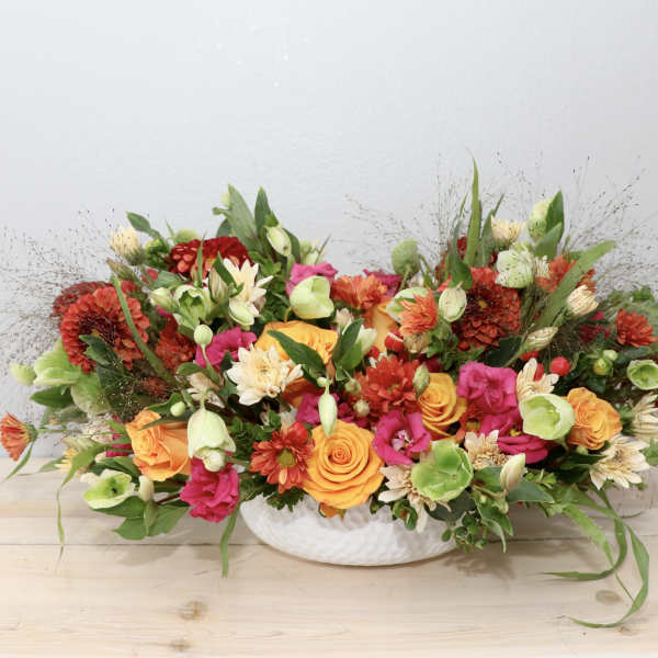 Colorful mixed flower arrangement in a white bowl vase