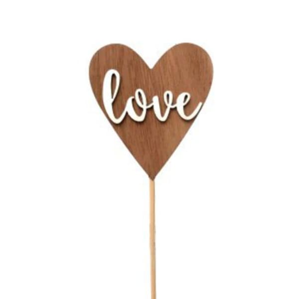 Wooden heart pick with the word love on a stick