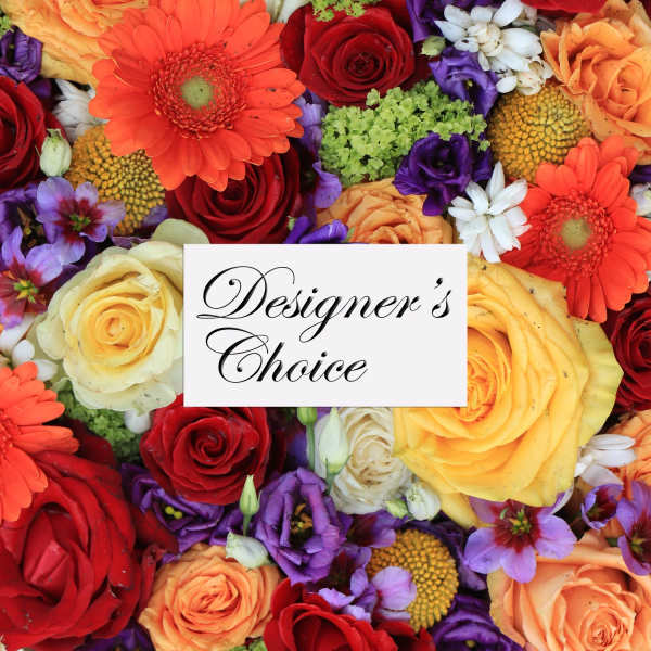 Mixed bouquet of roses, gerbera daisies, and purple blooms with a designer's choice card