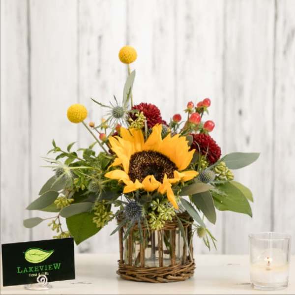 Sunflower arrangement in a glass vase with a wicker base