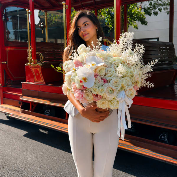 Woman holding a large bouquet of white and blush flowers