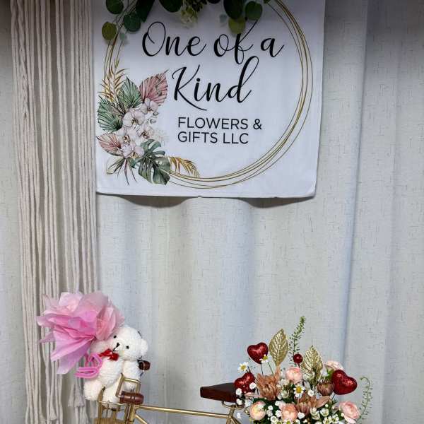Gold bicycle decor with a small floral arrangement and teddy bear